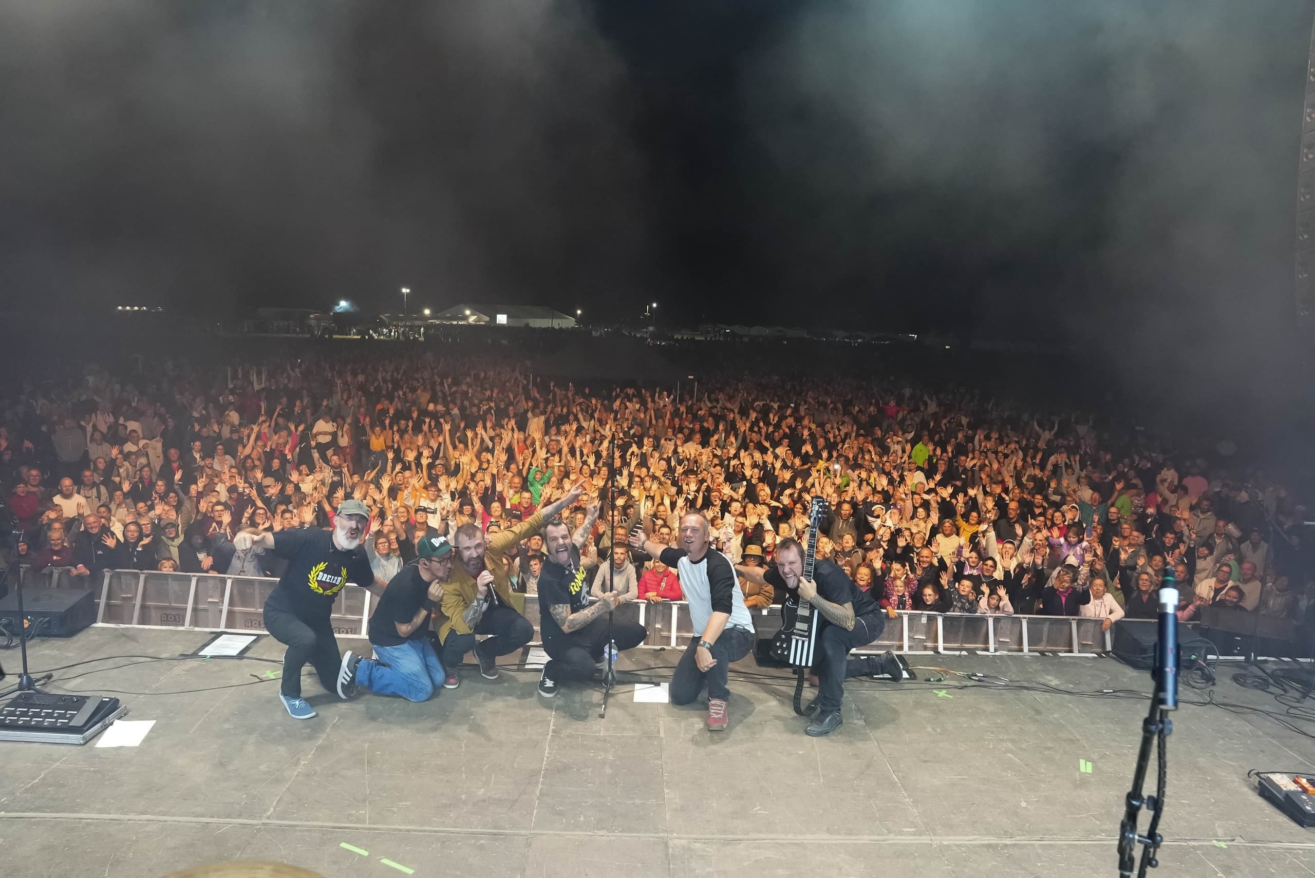 Groupe sur scène face à la foule d’un festival